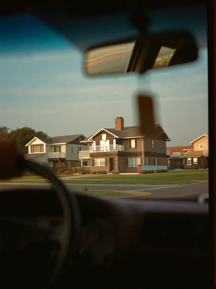 Driving past suburban houses at golden hour